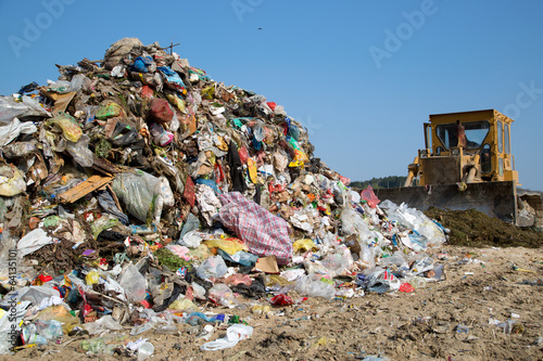 The old bulldozer moving garbage in a landfill photo