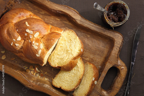 Sweet brioche bread on tray with knife and marmalade photo