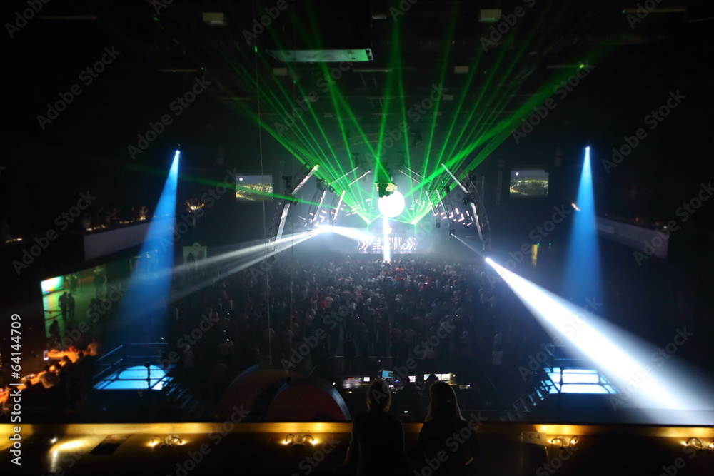 Fototapeta Crowd have fun on dancefloor with colored spotlights