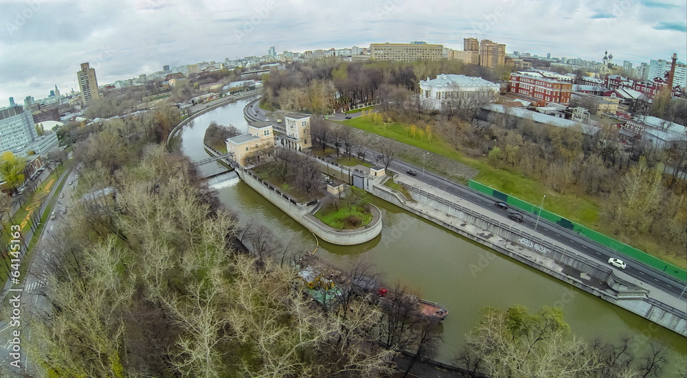 Fototapeta premium Yauza river with sluices of waterworks against the cityscape