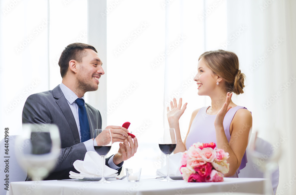 man proposing to his girlfriend at restaurant