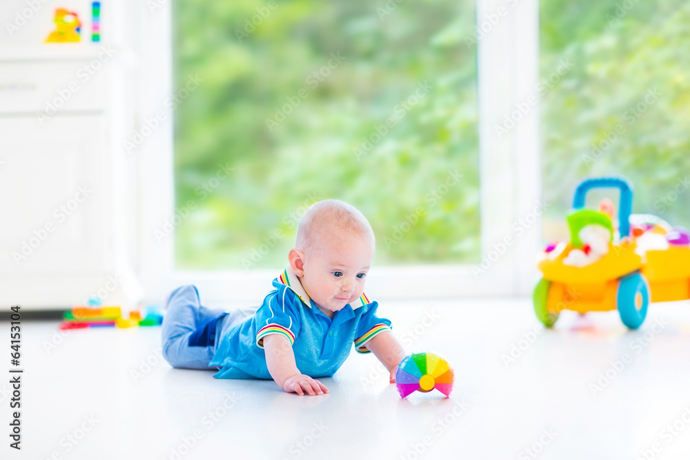 Funny baby boy with colorful ball and toy car next big window Funny baby boy with colorful ball and toy car next big window