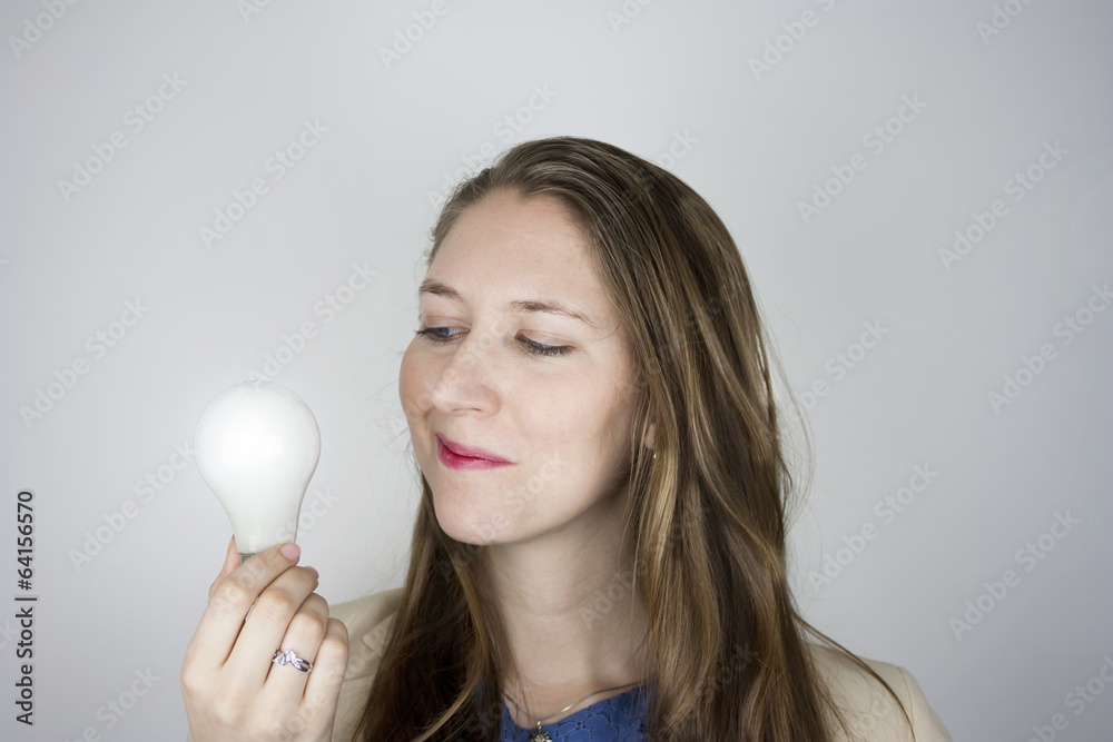 Pretty business woman holding a light bulb Pretty business woman holding a light bulb