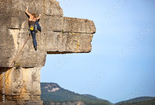 Young female rock climber on a cliff