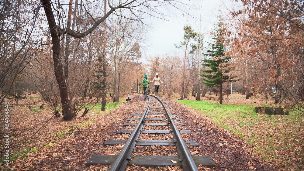 Walk Along The Rails, Man and Woman Walking in the Autumn Park Walk Along The Rails, Man and Woman Walking in the Autumn Park
