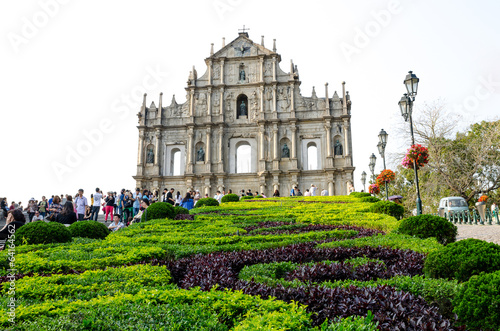  People under umbrellas in front of ruined church of St Paul 