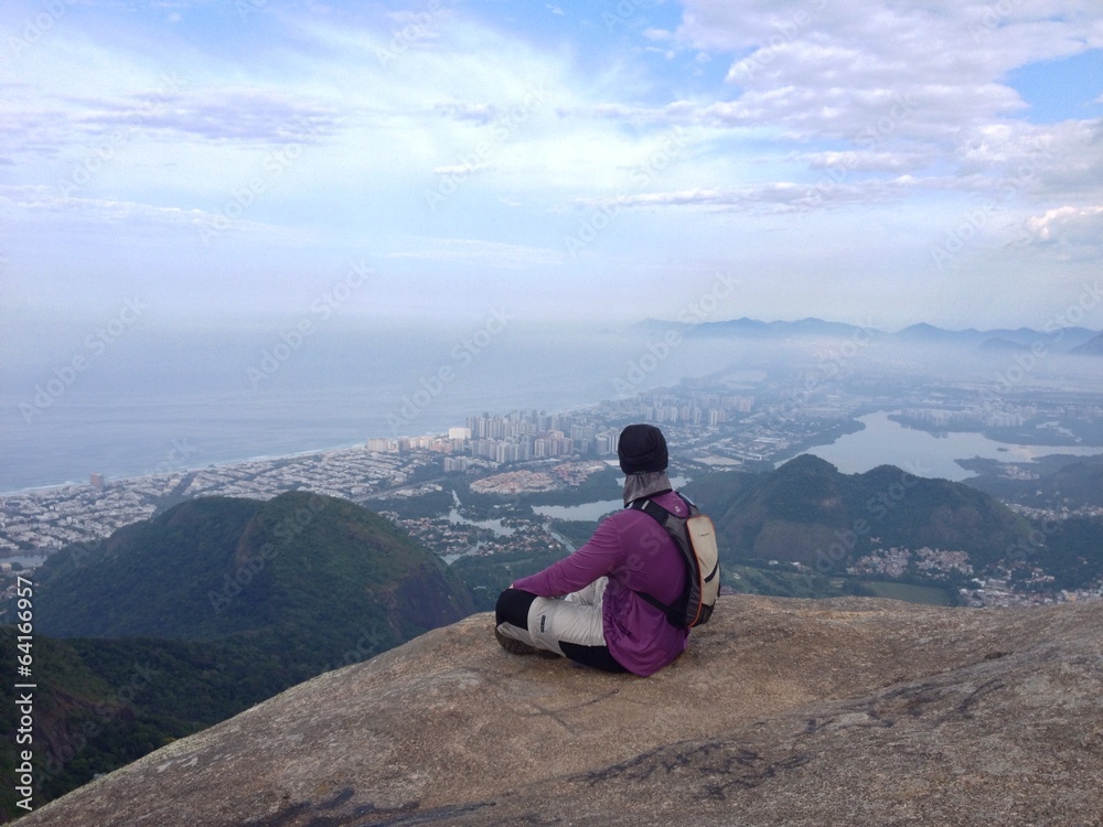 Man sitting on edge of mountain, Rio de Janeiro