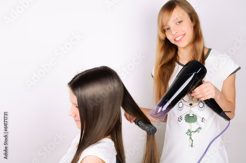 girl dries hair the hair dryer other teen girl