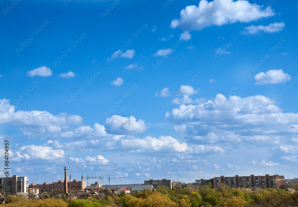 blue sky with field of green grass and city on the horizon