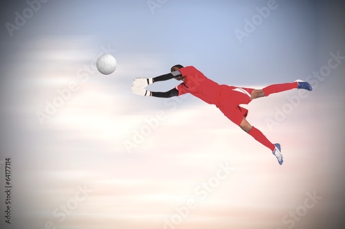 Composite image of goalkeeper in red making a save