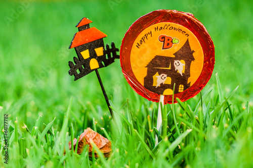 Wallpaper Mural Lollipop with happy Halloween sign stuck in the green grass Torontodigital.ca
