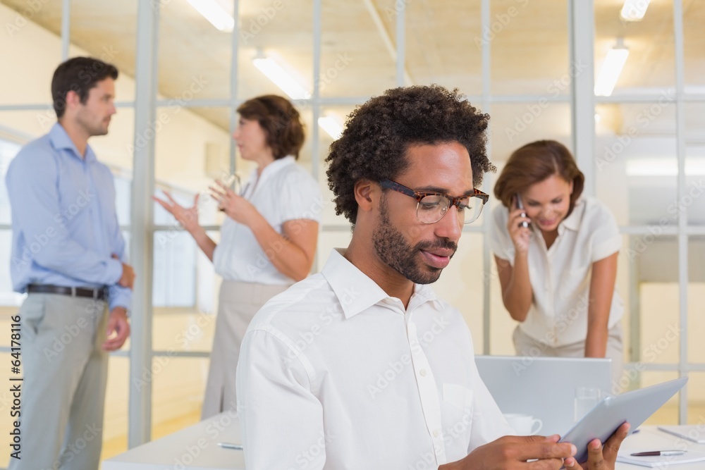 Concentrated businessman using digital table with colleagues at Concentrated businessman using digital table with colleagues at