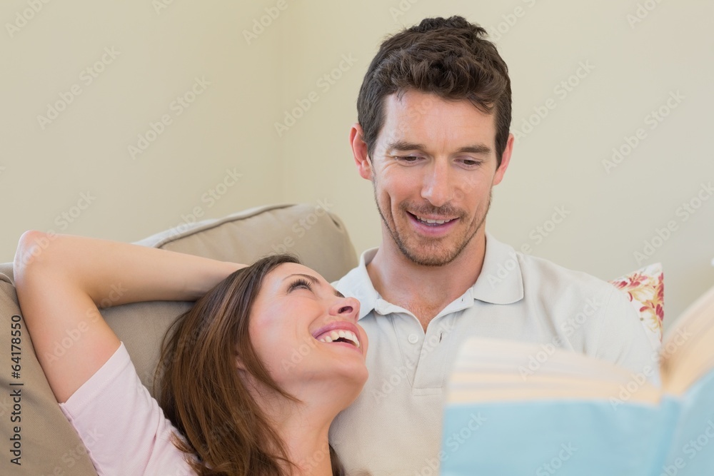 Fototapeta premium Loving couple reading book on couch