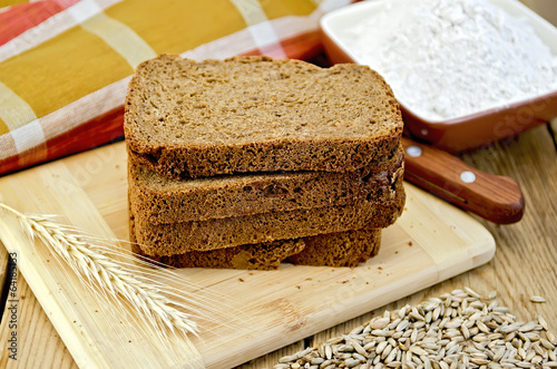 Rye bread with flour and grain on board
