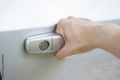 Close up of a man's hand pulling gray car's door handle