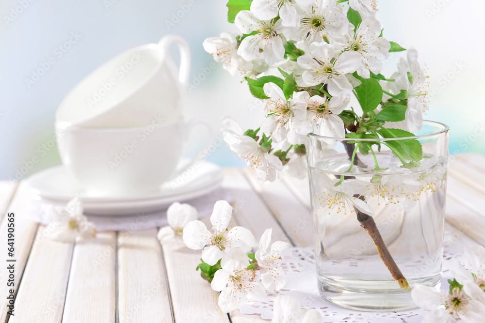 Beautiful fruit blossom in glass on table on light background Beautiful fruit blossom in glass on table on light background