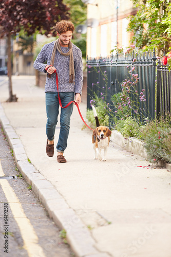 Man Taking Dog For Walk On City Street