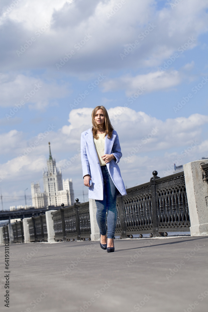Stylish young woman in a blue coat