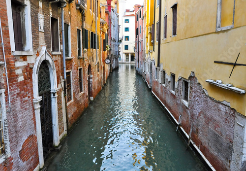 Narrow Venetian canal with gondolas in Venice, Italy. © lornet
