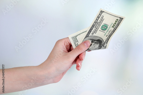 Dollars in hand on bright background