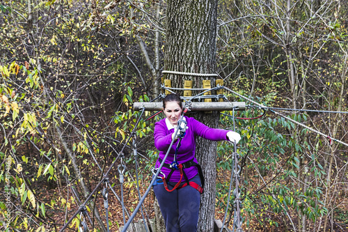 Young woman climbing in adventure park