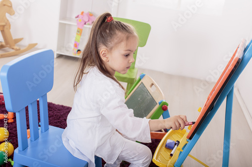 Little girl draw in the room