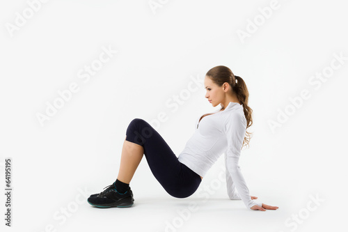 Young sporty girl does gymnastic exercises isolated