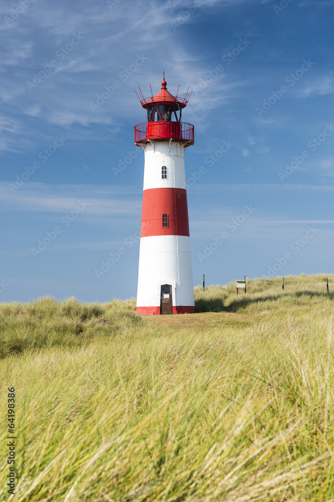 Red - white lightouse on wide dune on amazing German island Sylt. Red - white lightouse on wide dune on amazing German island Sylt.