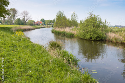 Fototapeta Naklejka Na Ścianę i Meble -  Curved stream in a polder landscape in springtime