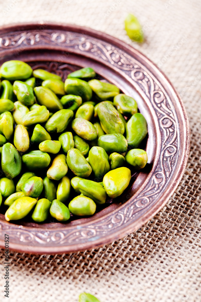 Pistachio nuts in a cooper authentic plate Pistachio nuts in a cooper authentic plate