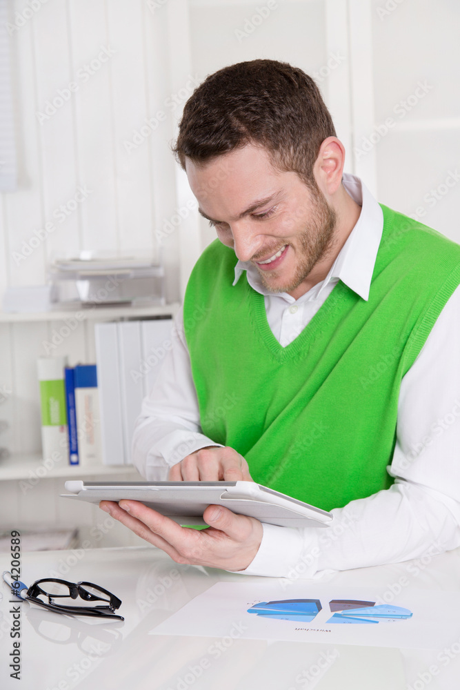 Lachender Business Mann liest in seinem Tablet-PC Lachender Business Mann liest in seinem Tablet-PC