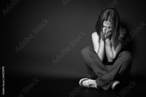 woman in depression and despair crying on black dark
