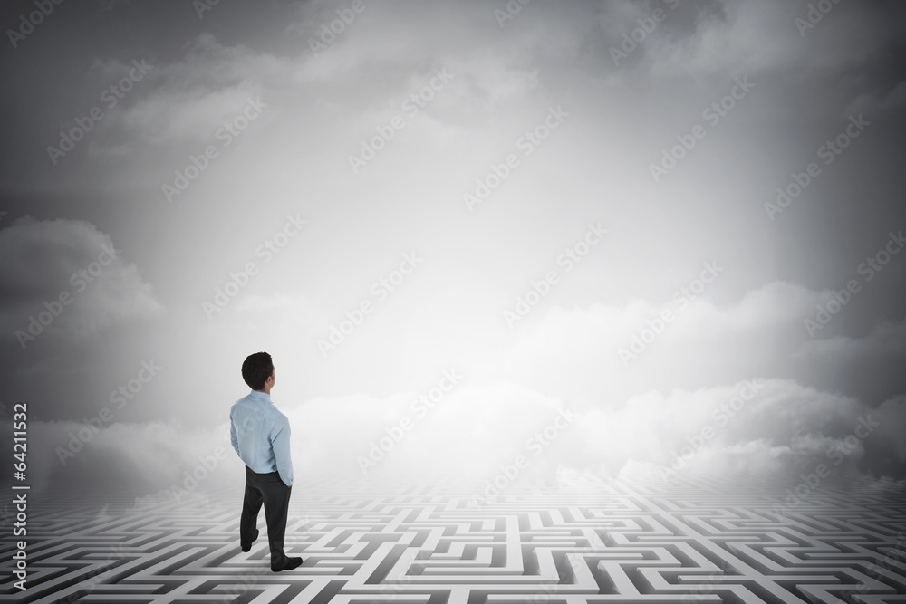 Composite image of businessman standing with hands in pockets