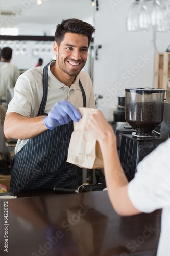 Waiter giving packed food to a woman at coffee shop