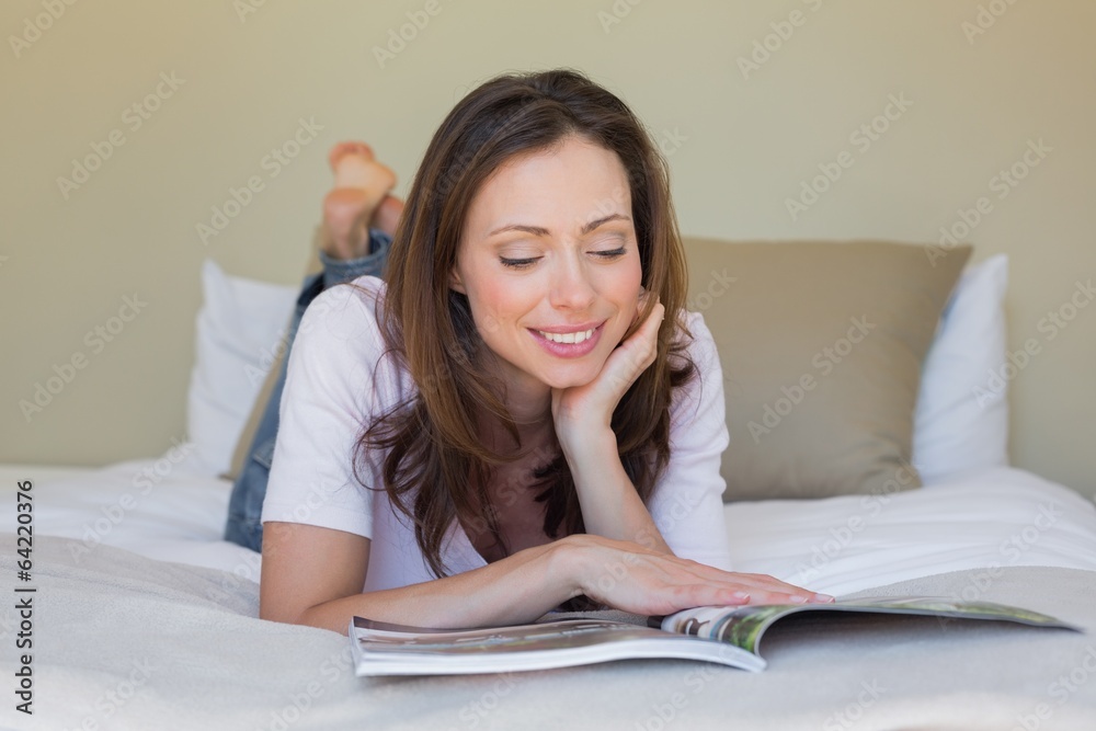 Smiling relaxed woman reading a book in bed Smiling relaxed woman reading a book in bed