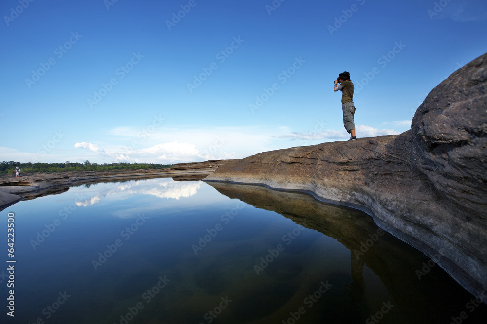 one man stand on stone and water in thailand
