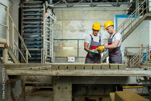 Worker and foreman performing quality check on a factory