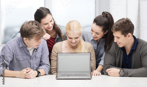 smiling students looking at blank lapotop screen