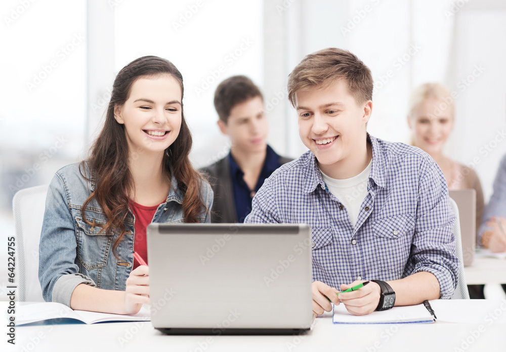 students with laptop and notebooks at school students with laptop and notebooks at school