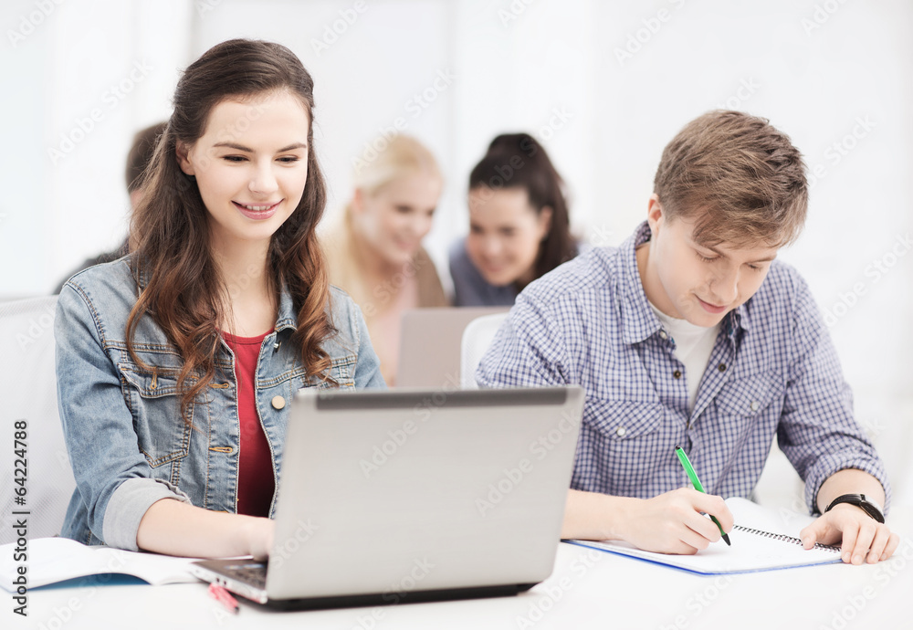 students with laptop and notebooks at school students with laptop and notebooks at school