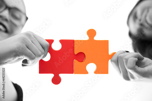 business women assembling jigsaw puzzle and