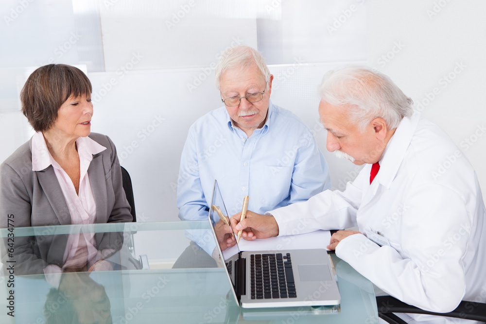 Obraz premium Doctor Writing Prescription For Senior Couple