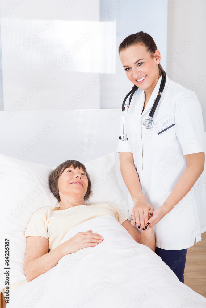 Fototapeta premium Female Doctor Consoling Senior Woman