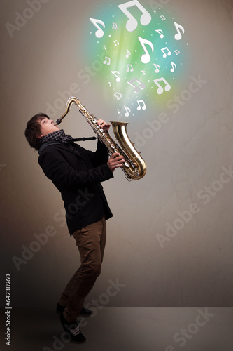 Young musician playing on saxophone while musical notes explodin photo