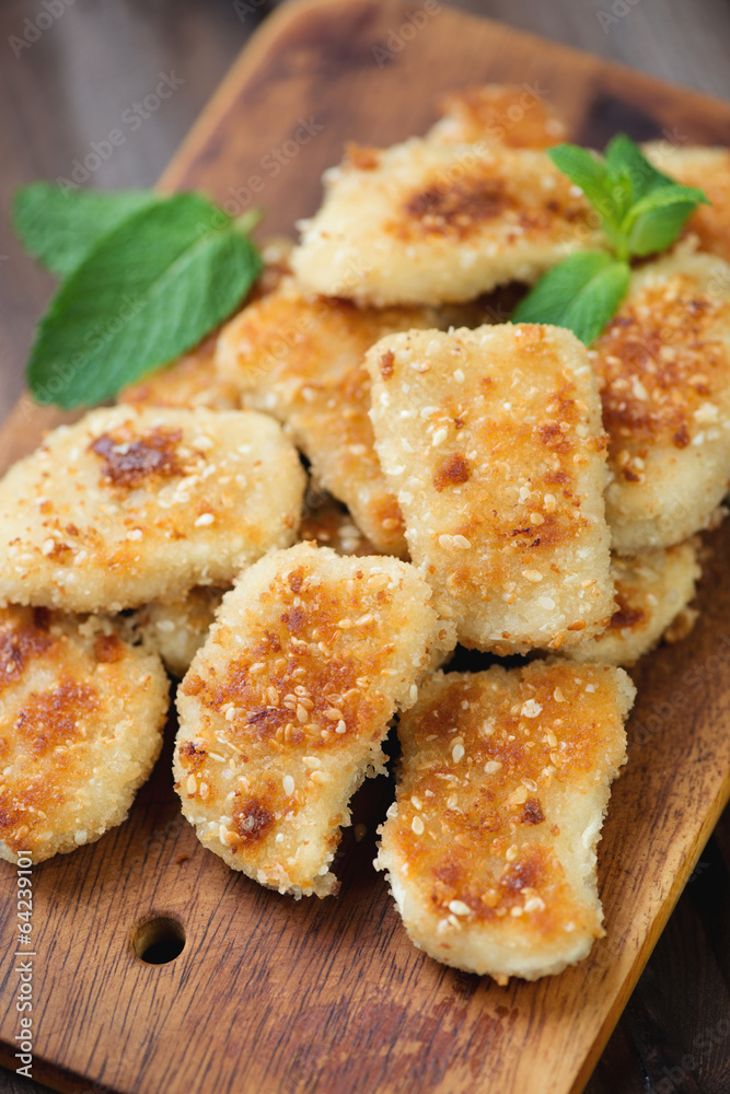 Fried chicken nuggets with mint leaves on a chopping board Fried chicken nuggets with mint leaves on a chopping board