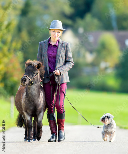 Foto Woman walking with pony and dog