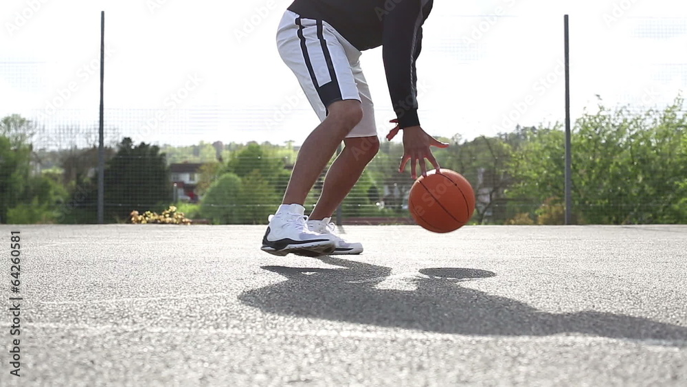 Male basketball player dribbling the ball skilfully