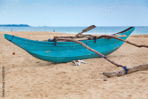 Fototapeta Naklejka Na Ścianę i Meble -  Traditional Sri Lankan fishing boat on empty sandy beach.