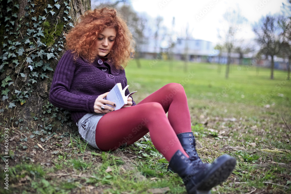 Girl reading a book at the park Girl reading a book at the park