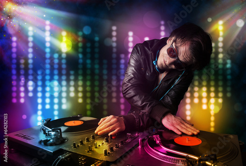 Dj playing songs in a disco with light show photo